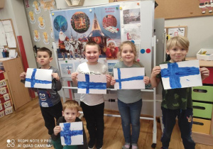 Dzieci pokazują swoje prace- flagi Finlandii.